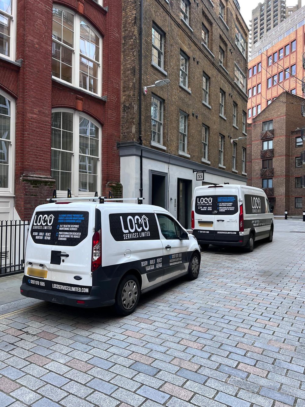 Two LOCO service vans parked on a London street